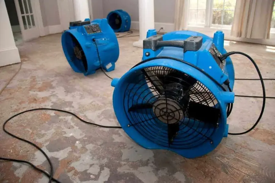 Air movers set on a wet floor during a Duluth water damage dry-out