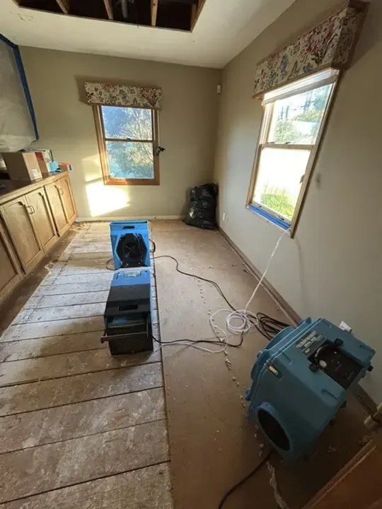 Air mover and dehumidifier drying a bedroom subfloor in Duluth