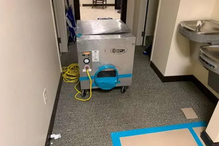 Commercial dehumidifier drying a carpeted hallway in a Duluth building