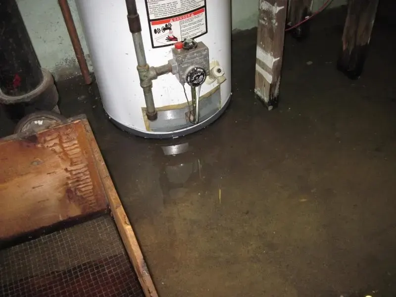 Leaking water heater standing in water on a Duluth utility room floor